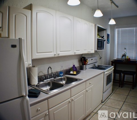 A kitchen with white cabinets and a sink.