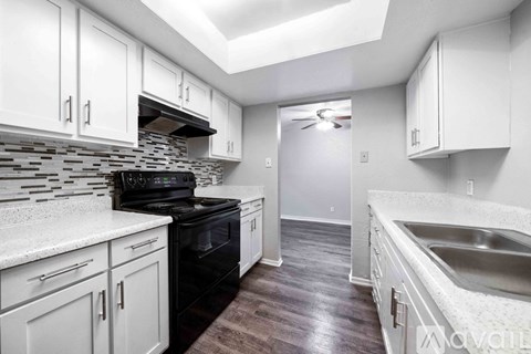 A kitchen with white cabinets and a black stove top oven.