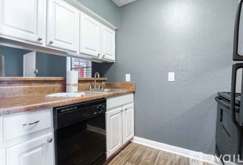 A kitchen with white cabinets and a black oven.
