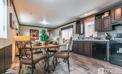 A kitchen with a table set for four and a Christmas tree in the corner.