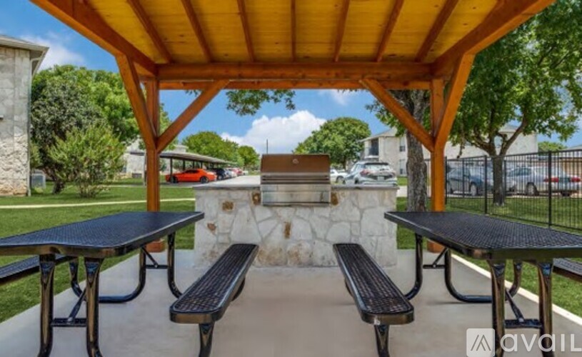 A covered picnic area with two tables and two benches.