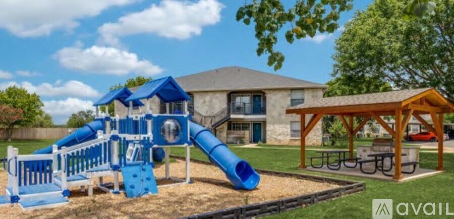 A playground with a blue slide and a wooden structure.