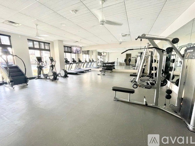 A gym with a variety of equipment including treadmills, weights, and exercise machines.