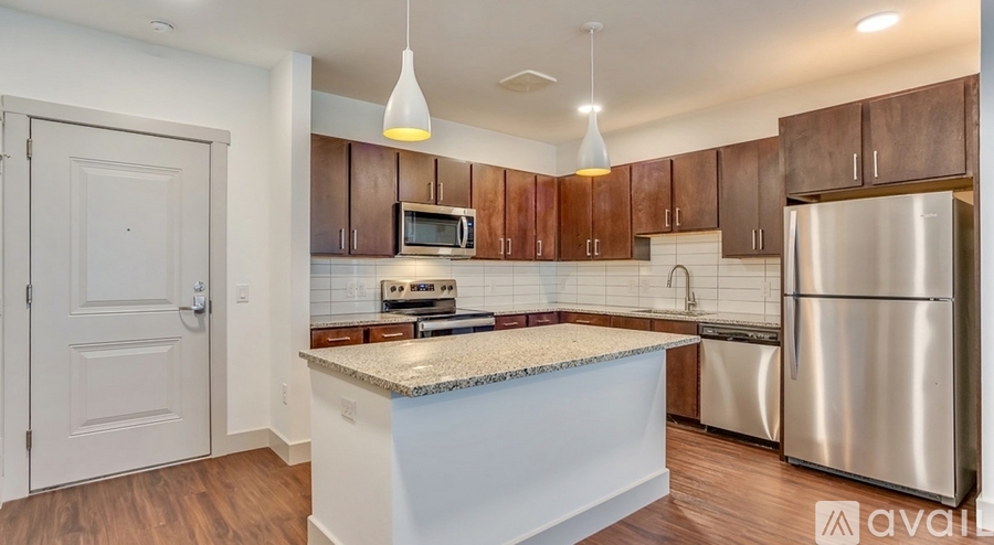 A kitchen with a stainless steel refrigerator and wooden cabinets.