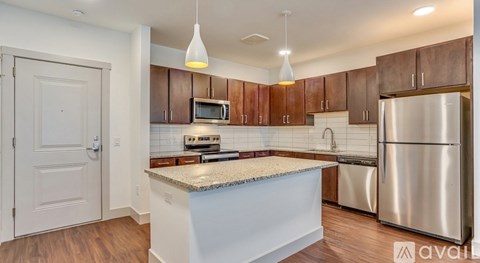 A kitchen with a stainless steel refrigerator and wooden cabinets.