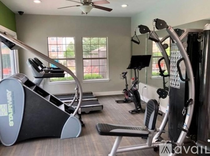 A gym with a treadmill, elliptical machines, and other exercise equipment.