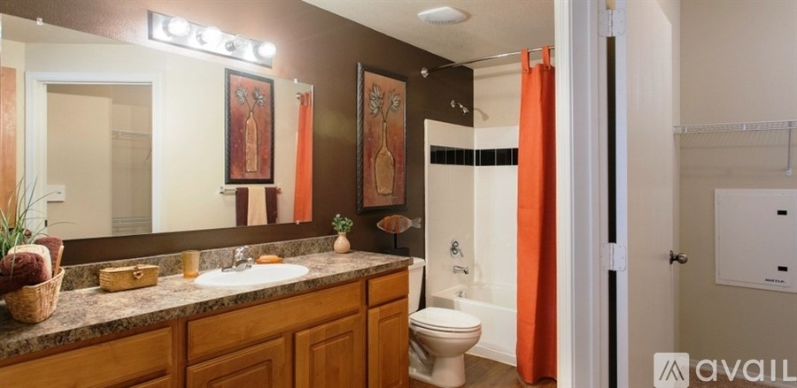 A bathroom with a toilet, sink, and mirror.