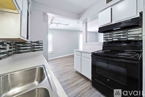 A modern kitchen with a black oven and a stainless steel sink.