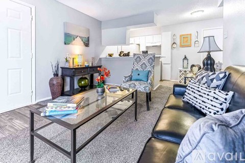 A living room with a glass coffee table and a blue couch.