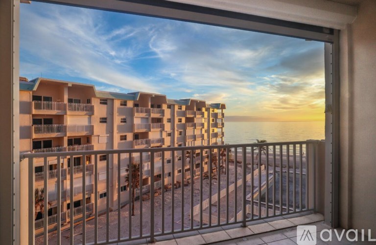 A balcony view of apartment buildings with a sunset sky.