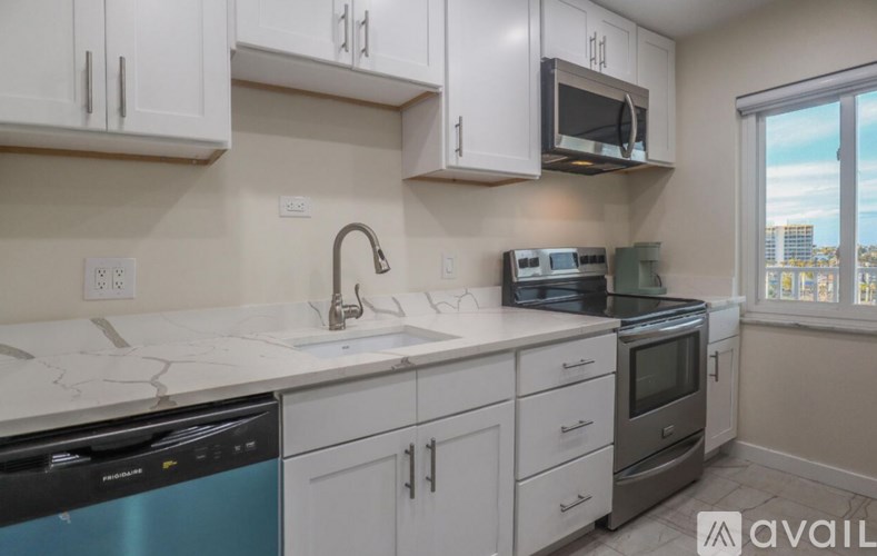 A kitchen with white cabinets and a blue dishwasher.