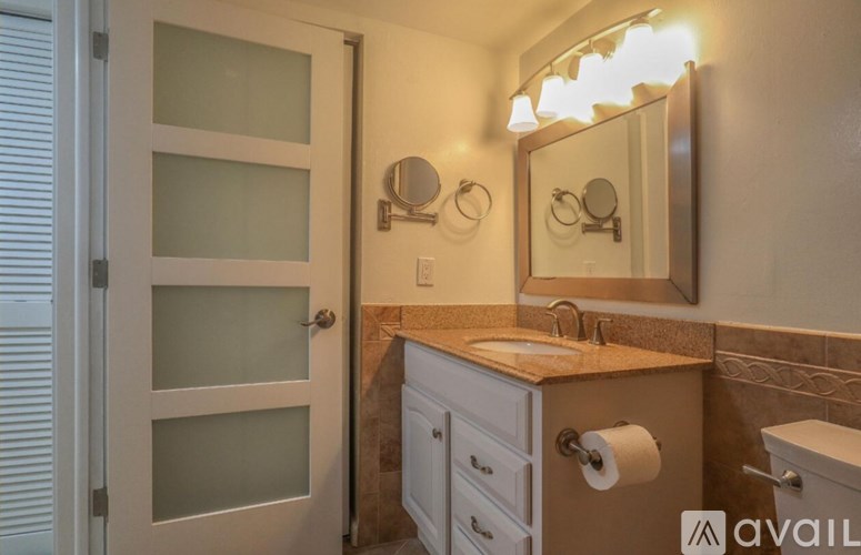 A bathroom with a sink, mirror, and toilet paper.