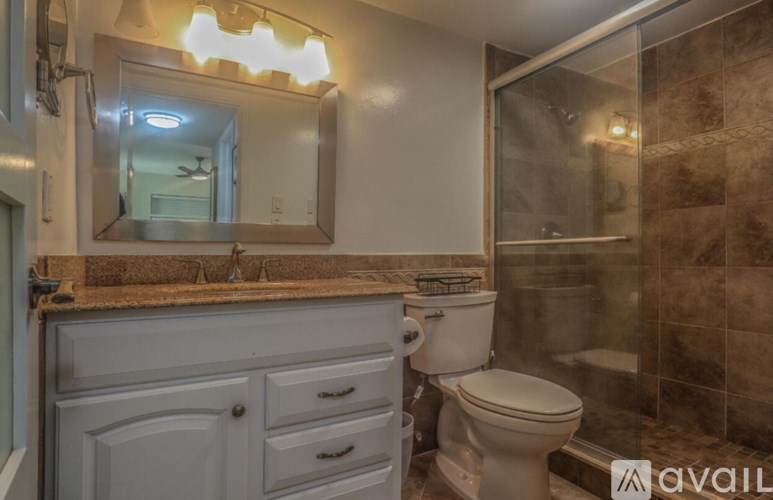 A bathroom with a toilet, sink, and mirror.