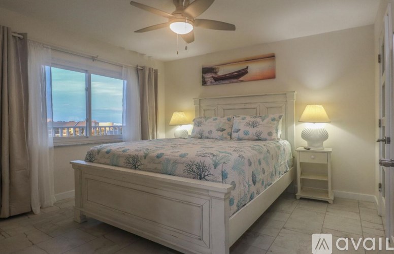 A bedroom with a large bed and a ceiling fan.