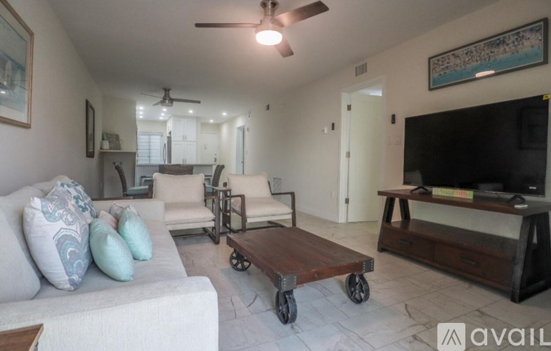 A living room with a white couch and a wooden coffee table.