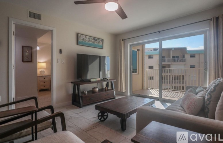 A living room with a television and sliding glass doors.