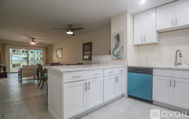 A kitchen with white cabinets and a blue dishwasher.