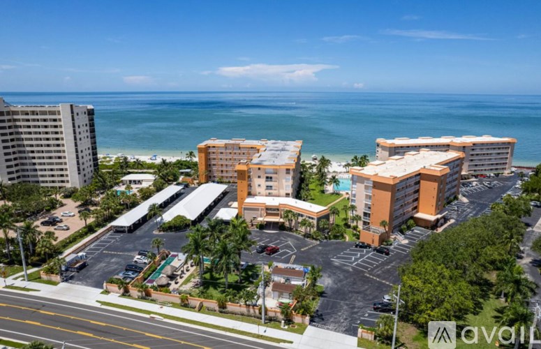 A view of a resort with a parking lot in front of it.