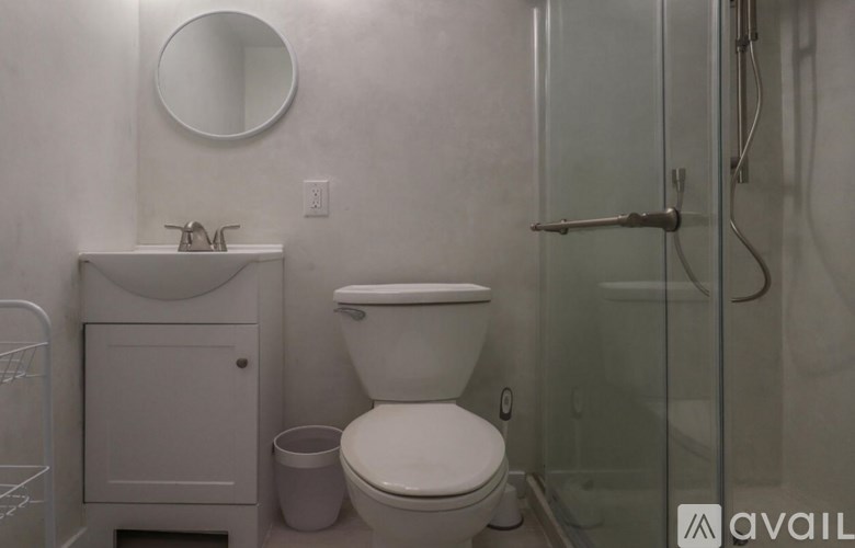 A white toilet sits in a bathroom next to a sink and a shower.