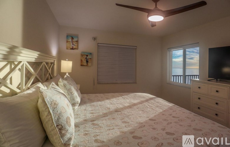 A bedroom with a bed, dresser, and window.