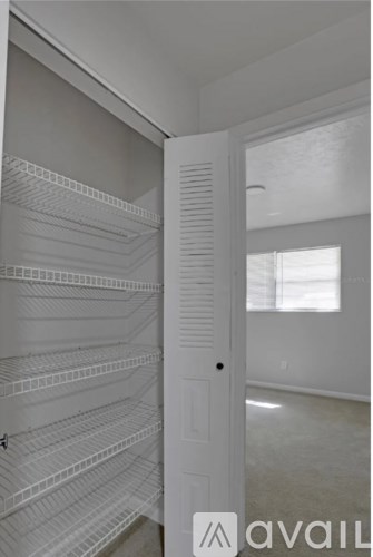 A white pantry with shelves and a door.