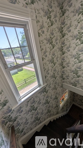 A window with a view of a green field and a fence.