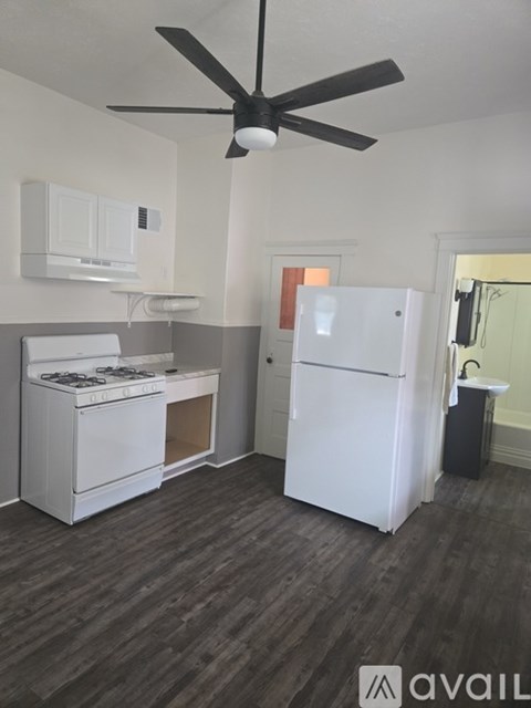 A kitchen with a white fridge and stove top oven.