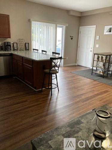 A kitchen with wooden floors and a bar area.