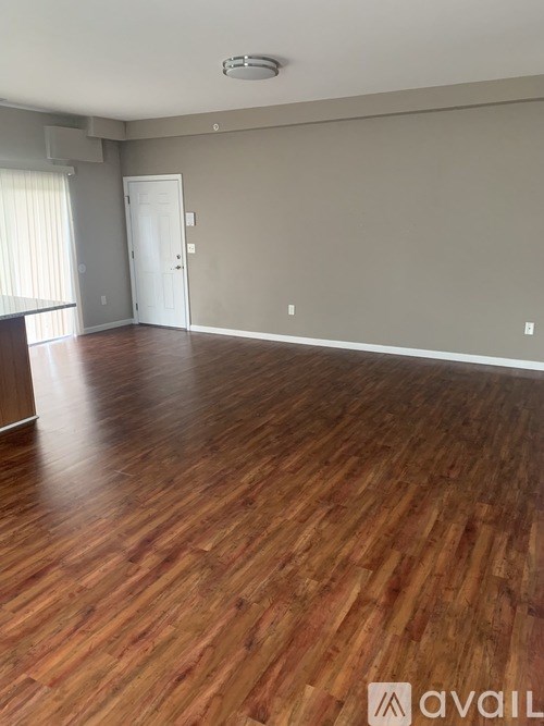 A room with wooden flooring and a white door.