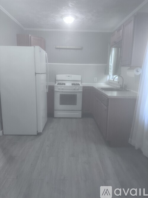 A small kitchen with a white refrigerator and a white stove top oven.