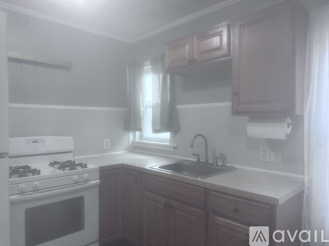 A kitchen with a white stove and wooden cabinets.