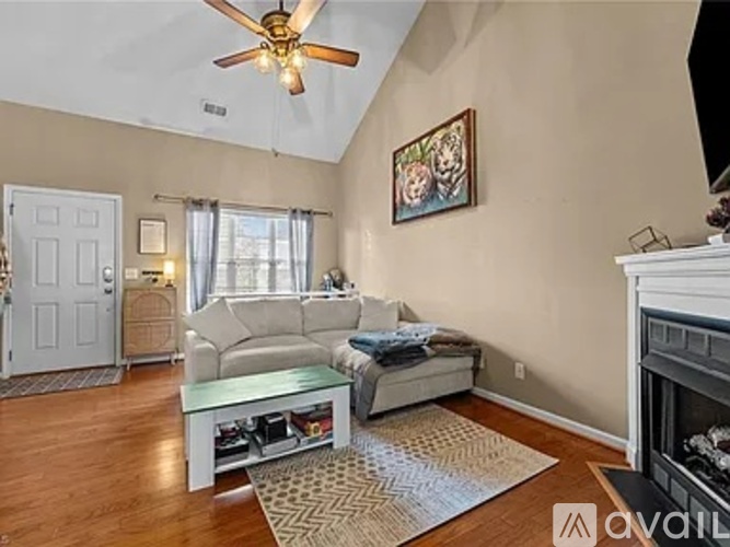 A living room with a white couch and a painting on the wall.