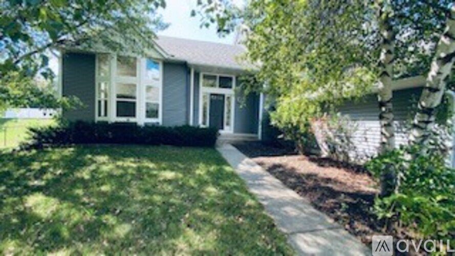 A house with a green lawn and a white fence.