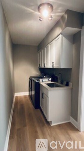 A small kitchen with black appliances and white cabinets.