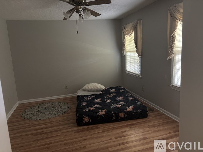 A bedroom with a bed, a ceiling fan, and a rug.