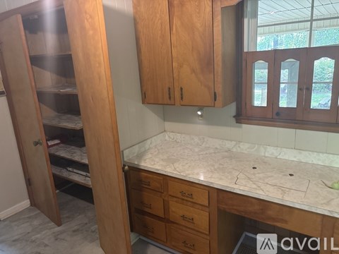 A kitchen with wooden cabinets and a marble countertop.