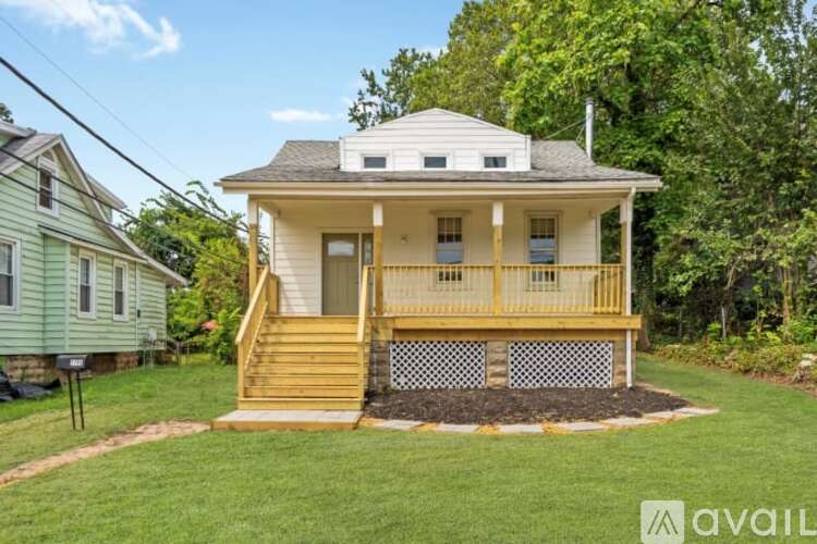 A two-story house with a front porch and a staircase leading to the upper floor.