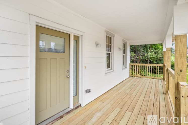 A wooden deck leads to a white door.