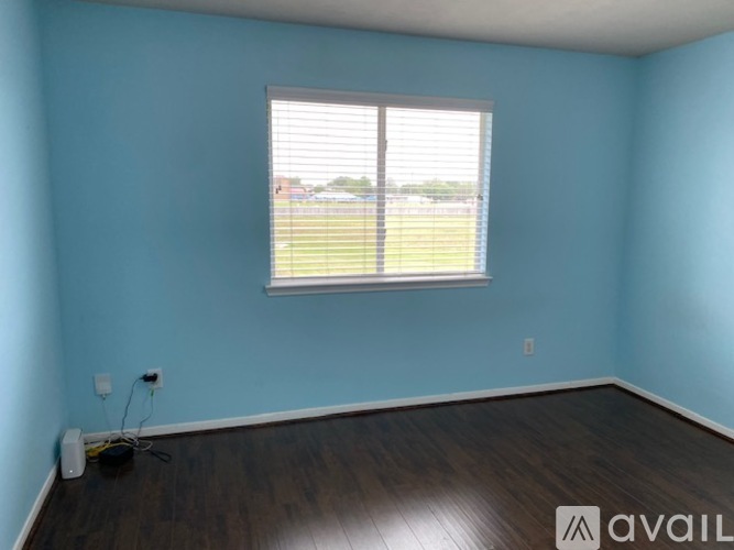 A room with a window and wooden flooring.