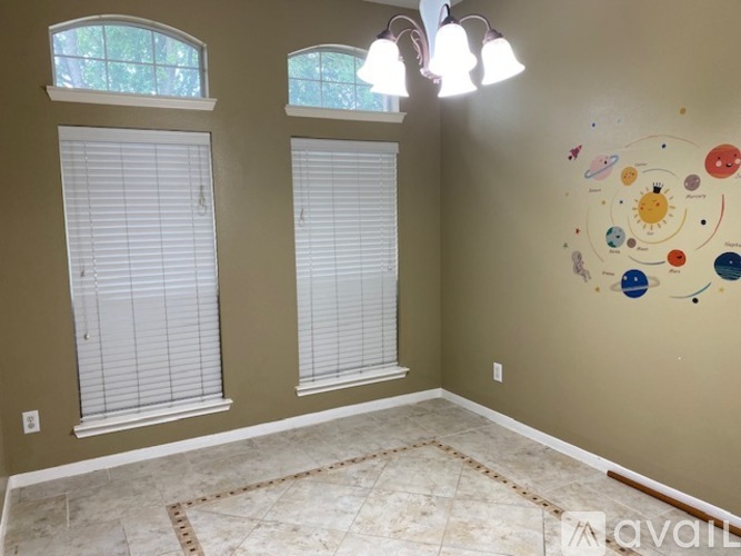 A room with a wall art of planets and stars.