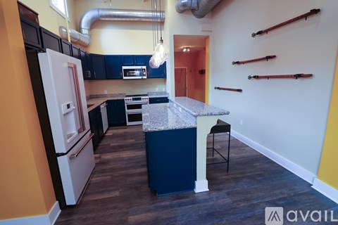 A kitchen with a white refrigerator and black cabinets.