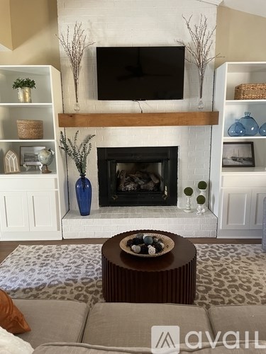 A living room with a fireplace and a television above it.