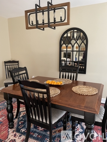 A dining room with a wooden table and chairs.