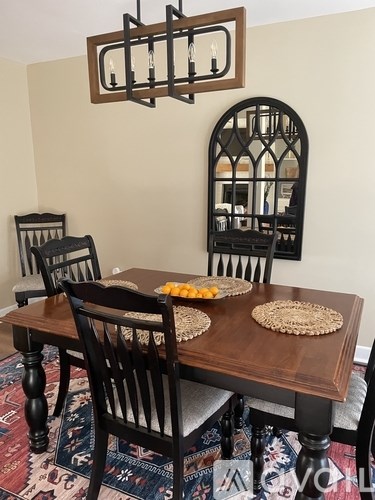 A dining room with a wooden table and chairs.