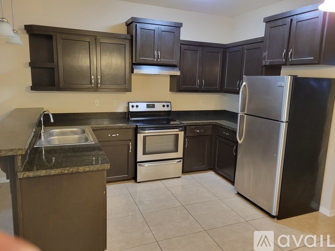 A kitchen with dark brown cabinets and stainless steel appliances.