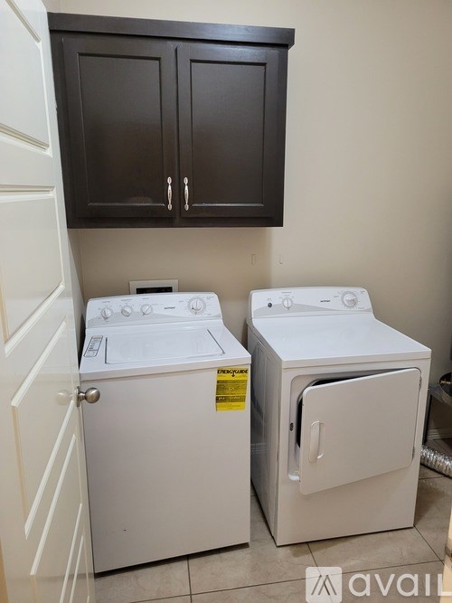 A white washing machine and dryer in a small laundry room.