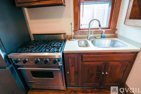 A kitchen with a stove and sink.