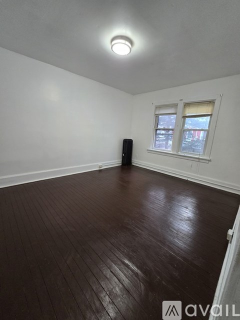 A room with a wooden floor and a window.