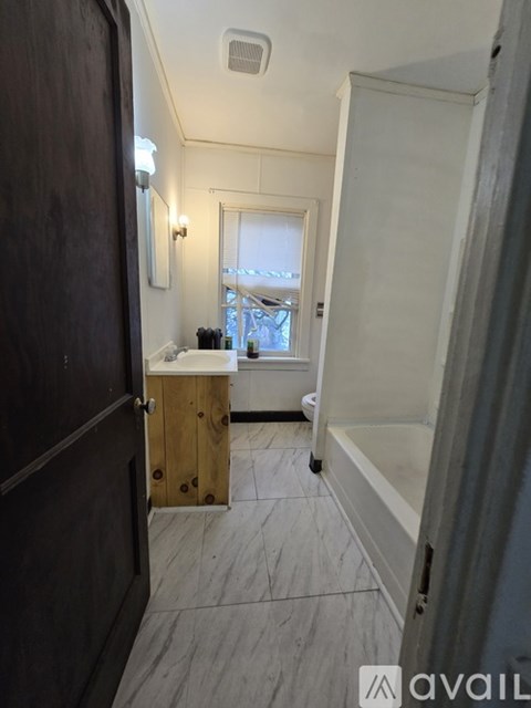 A bathroom with a sink, mirror, and a window.