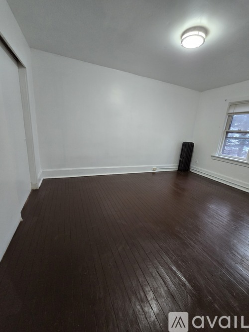 A room with wooden flooring and a window.
